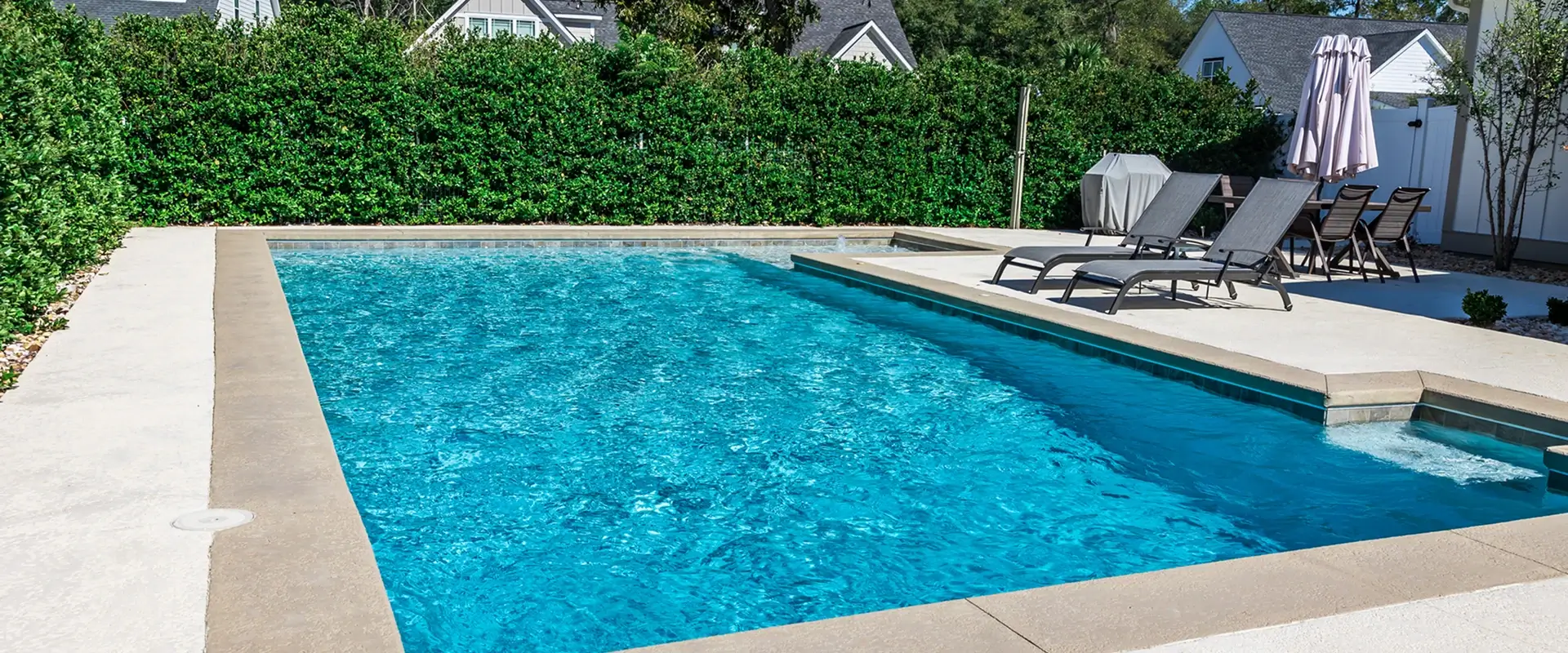 Backyard swimming pool with lounge chairs.